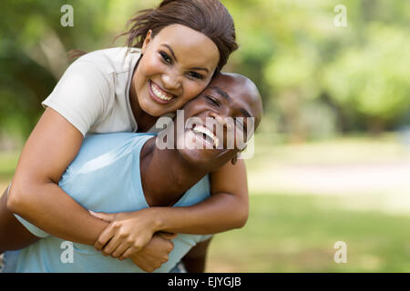 attractive young black couple piggybacking outdoors