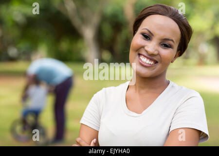 beautiful African woman standing in front of family outdoors