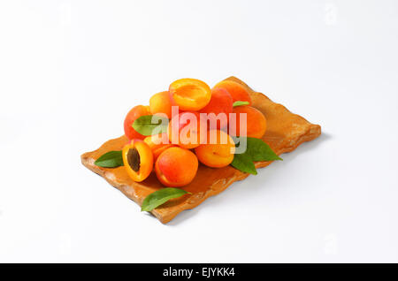 Heap of ripe apricots on wooden cutting board Stock Photo