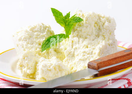 Crumbly white cheese on plate Stock Photo