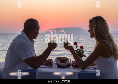 couple drinking wine silhouette romantic date vacation summer sea restaurant Stock Photo