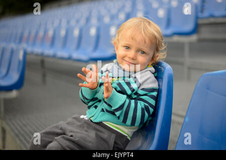 The little boy sits on a tribune Stock Photo