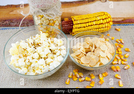 Ear of corn, popcorns and cornflakes in a glass jar on a vintage table Stock Photo