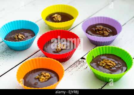 Chocolate Truffles in Colorful Cups on White Wooden Table Stock Photo