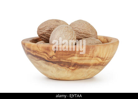 whole dried nutmegs in bowl, isolated Stock Photo