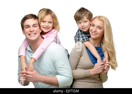 Smiling children riding piggyback on parents Stock Photo