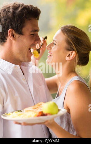 https://l450v.alamy.com/450v/ejyymm/cheerful-young-woman-feeding-boyfriend-breakfast-ejyymm.jpg