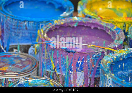 Colorful dripping paint on sides of paint cans. Stock Photo
