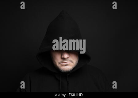 man wearing black hoodie hiding eyes Stock Photo