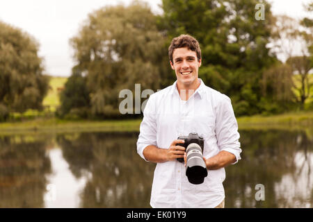 portrait of young man holding digital camera Stock Photo