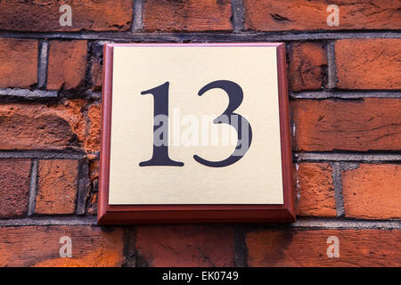 A plaque on a wall displaying the Number 13. Stock Photo