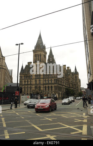 Grey sky portrait East Facade Manchester Town Hall from cars crossing intersection of Princess Street and Mosley Street ,UK