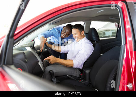 happy middle aged man checking car features in showroom Stock Photo