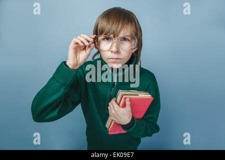 European-looking boy of ten years in glasses  with a book  showi Stock Photo