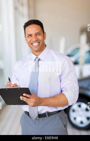 handsome car dealership salesman working in showroom Stock Photo