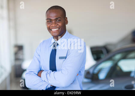 portrait of happy African car salesman in showroom Stock Photo