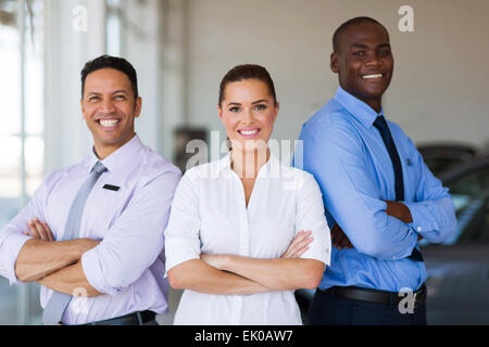 vehicle sales team with arms crossed inside car showroom Stock Photo