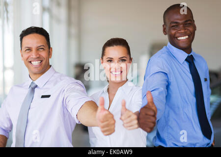 cheerful vehicle sales team giving thumbs up Stock Photo