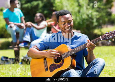 happy young African American college boy playing guitar on campus Stock Photo