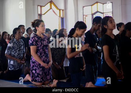 Larantuka, Indonesia. 3rd April, 2015. People queue to devote an old Mother Mary statue locally known as Tuan Ma at Tuan Ma chapel in Larantuka, Flores Island, Indonesia. Thousands of people, including those from other cities and countries, attend a whole week ceremonies to celebrate Holy Week in the small town of Larantuka, one of the most influential cities in Indonesia in terms of Roman Catholic traditions. Stock Photo