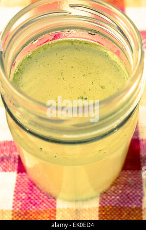 Meat broth in a glass jar. On the table, a vertical view. Stock Photo