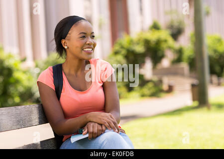 beautiful young African college students sitting on bench Stock Photo