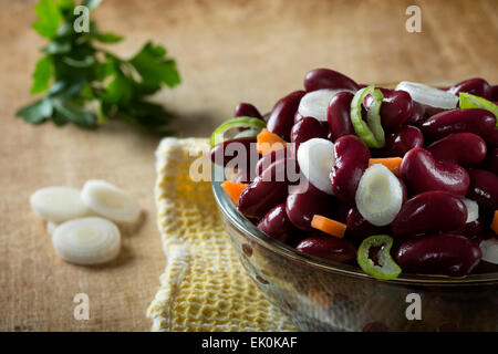 Salad of beans in glass bowl over wood background Stock Photo