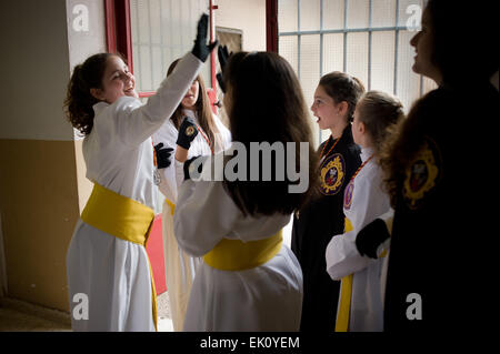 April 3, 2015 - Badalona, Barcelona, Spain -  Young members  from Santísimo Cristo Redentor brotherhood play  inside the church  Sant Antoni de Llefia in Badalona (Spain) before take part in a procession. The Good Friday procession is held in the district of Llefia in Badalona (Barcelona). This neighborhood is home mostly population of Andalusian origin and at this time (Easter) shows the typical religious processions of southern Spain. Stock Photo