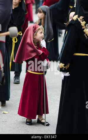 Hooded girl walking, in Procession, Holy week, Semana Santa, Malaga, Andalusia, Spain. Stock Photo