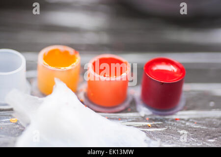 Colourful tattoo ink in small cups ready for being used on a tattoo, shot in a tattoo parlor Stock Photo