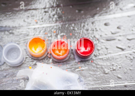 Colourful tattoo ink in small cups ready for being used on a tattoo, shot in a tattoo parlor Stock Photo