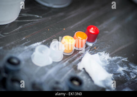 Colourful tattoo ink in small cups ready for being used on a tattoo, shot in a tattoo parlor Stock Photo