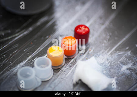 Colourful tattoo ink in small cups ready for being used on a tattoo, shot in a tattoo parlor Stock Photo