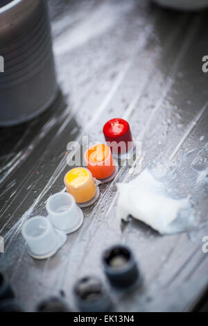 Colourful tattoo ink in small cups ready for being used on a tattoo, shot in a tattoo parlor Stock Photo