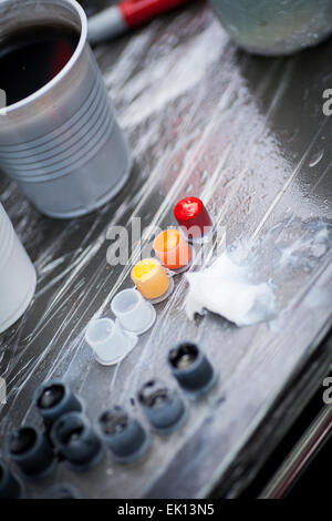 Colourful tattoo ink in small cups ready for being used on a tattoo, shot in a tattoo parlor Stock Photo