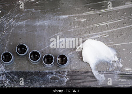 Black tattoo ink in small cups ready for being used on a tattoo, shot in a tattoo parlor Stock Photo