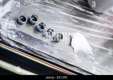 Black tattoo ink in small cups ready for being used on a tattoo, shot in a tattoo parlor Stock Photo