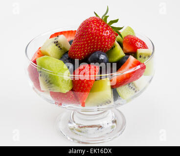 Fresh mixed fruit salad in a glass bowl isolated on a white background Stock Photo