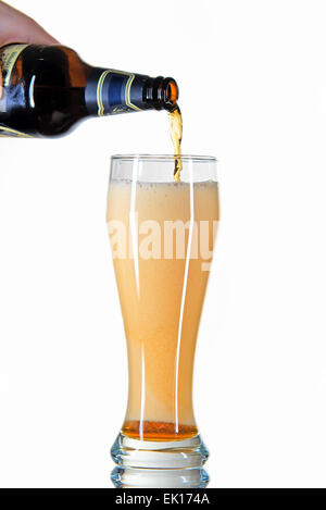 beer from a bottle poured into a glass on a white background Stock Photo