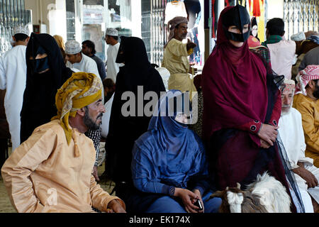 Bedu (Bedouin) people buying and selling goats at animal market in Sinaw, Oman Stock Photo