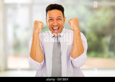 portrait of happy businessman waving fists indoors Stock Photo