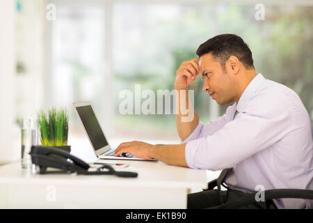 worried middle aged businessman looking at computer screen Stock Photo