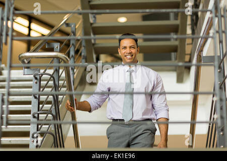 handsome middle aged businessman walking up stairs Stock Photo