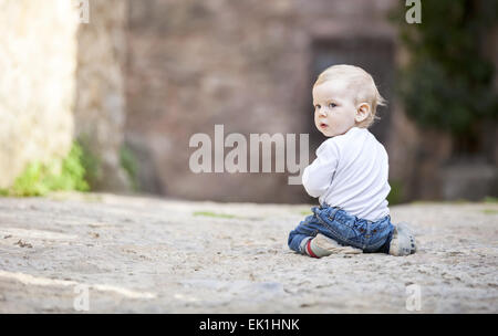 Little boy crawling on stone paved sidewalk Stock Photo