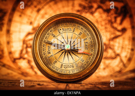 Vintage still life. Vintage compass lies on an ancient world map. Stock Photo