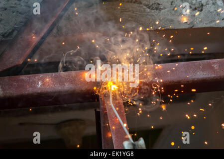 welding steel with spread spark lighting smoke Stock Photo