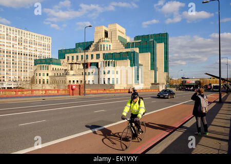 27 March 2015 - Vauxhall, London: A cyclist in the cycle lane crossing Vauxhall bridge in front of the headquarters building of Stock Photo