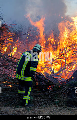fireman attending Easter eve bonfire, Neetze, Lower Saxony, Germany Stock Photo
