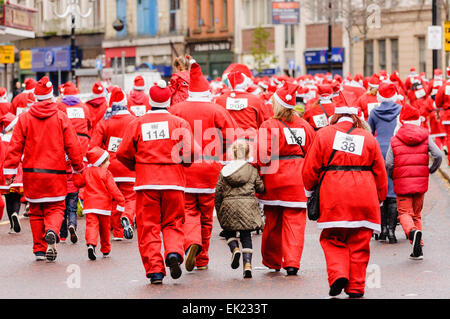 Belfast, Northern Ireland. 1st Dec 2013 - Runners make their way along the course of Cool FM's 'Santa Dash' to raise cash for Cash For Kids and Barnardos charities Stock Photo
