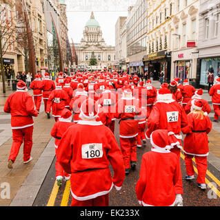 Belfast, Northern Ireland. 1st Dec 2013 - Santa runners pass Belfast City hall as Cool FM's 'Santa Dash' raises cash for Cash For Kids and Barnardos charities Stock Photo